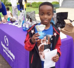 Kid holding giveaway he received from MECU