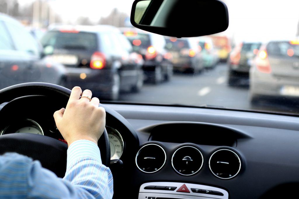 The driver waits in a big traffic jam in the car.