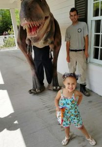 Child and dinosaur mascot at CU at the Zoo.