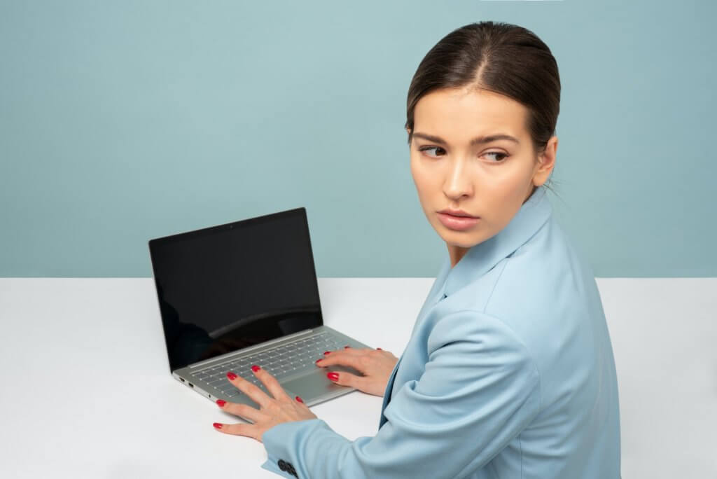 woman looking over her shoulder at computer