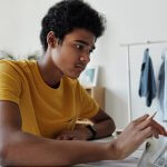 Young man working on a tablet with pencil in hand.