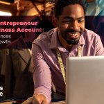Smiling entrepreneur working on a laptop in a small business workspace.