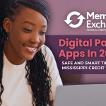 Smiling young woman using a laptop while holding a card, representing safe use of digital payment apps in 2025 for Mississippi credit union members.