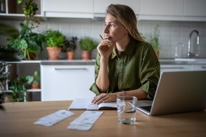 Woman reviewing bills and budgeting at home to avoid tax season mistakes before filing
