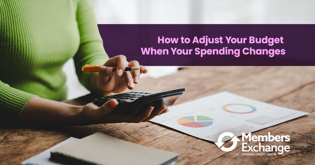 Person using a calculator to adjust a monthly budget as spending changes